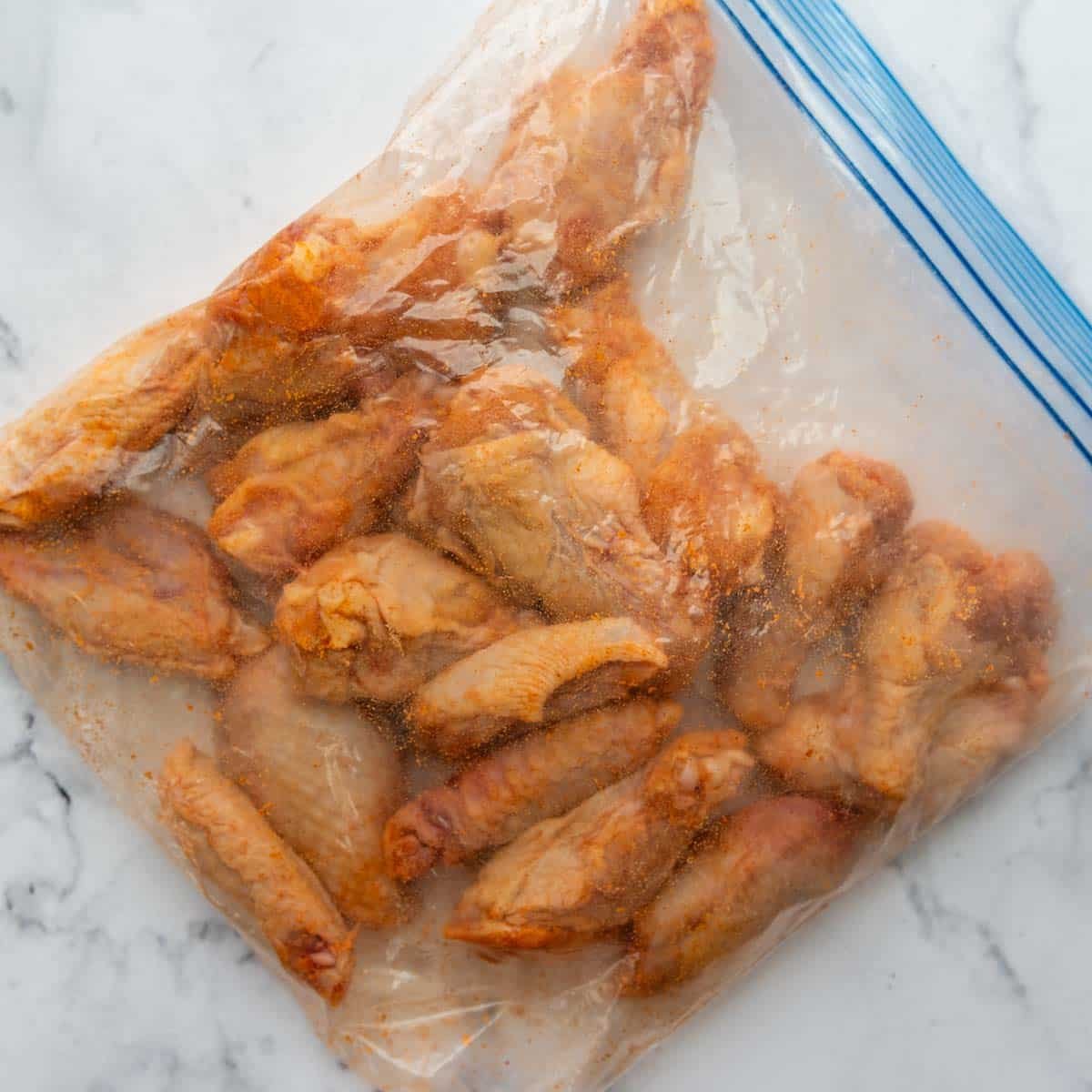 unbaked wings in a ziplock bag.