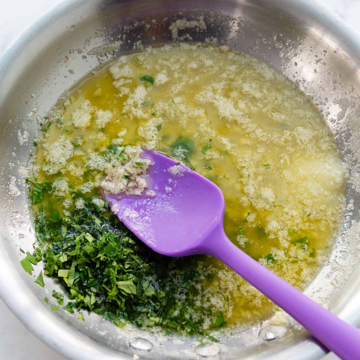 melted butter in a skillet with garlic and parsley.