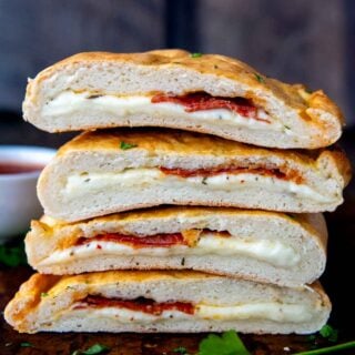 a stack of calzones sliced in half on top of each other.