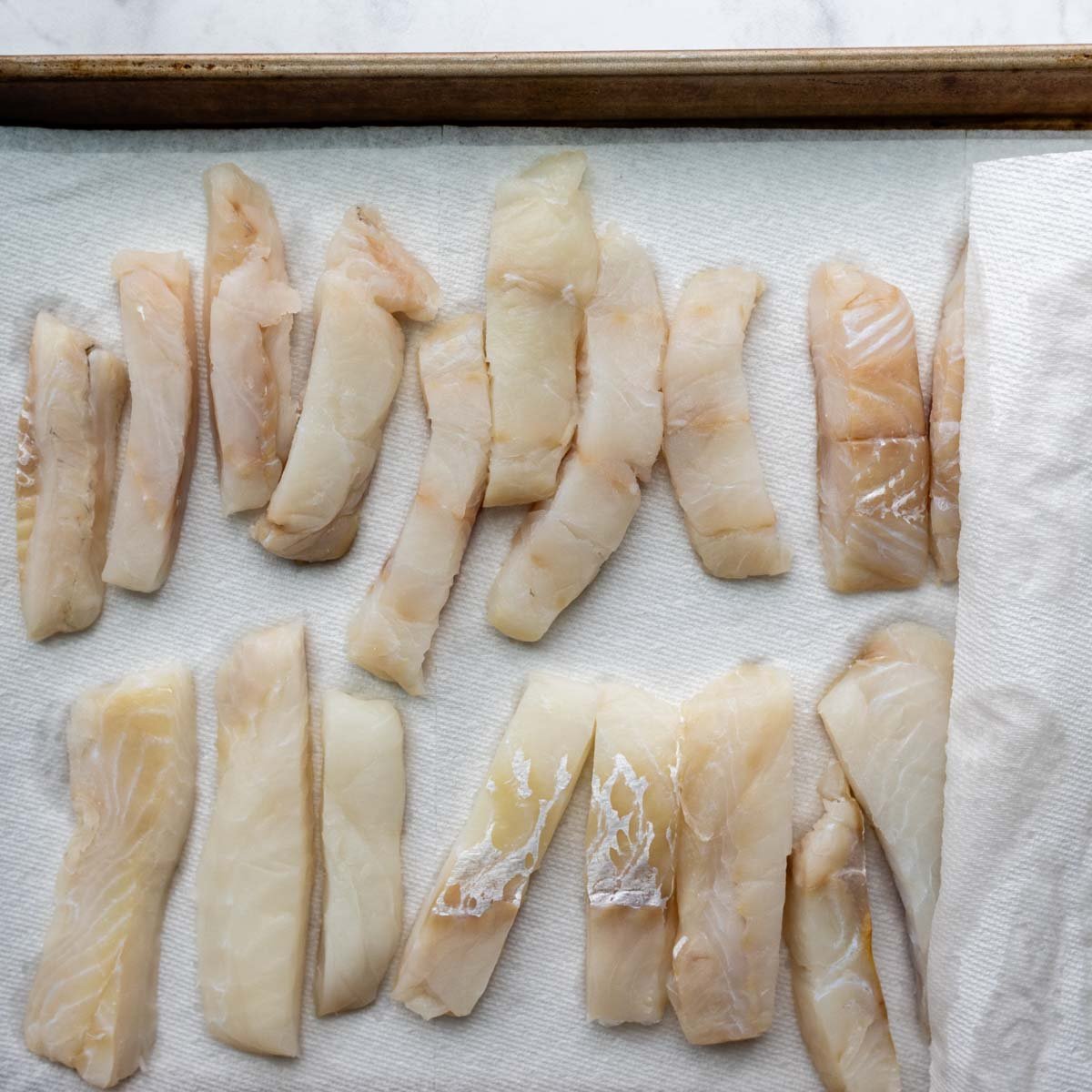 cut fish on a baking sheet lined with paper towels.