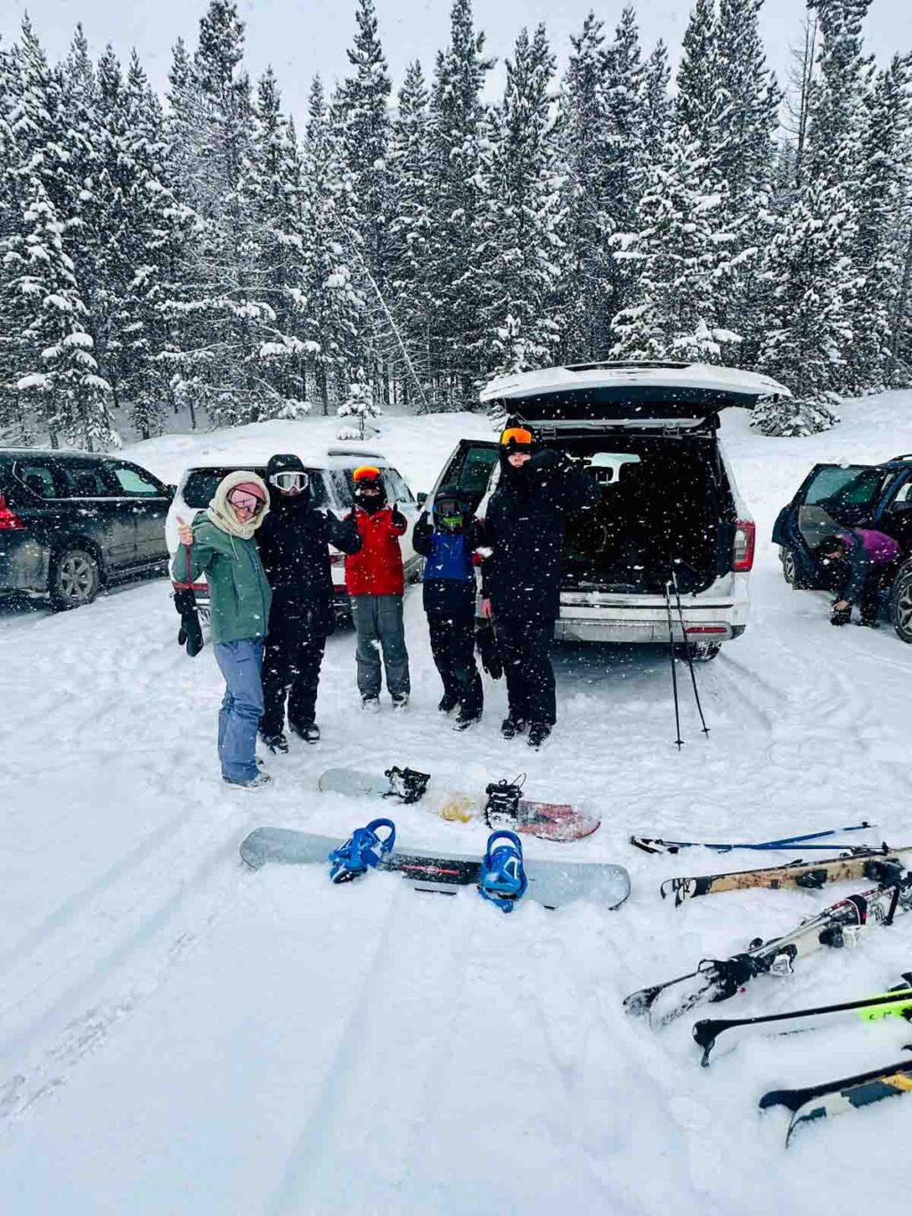 family getting ready to ski posing by car.