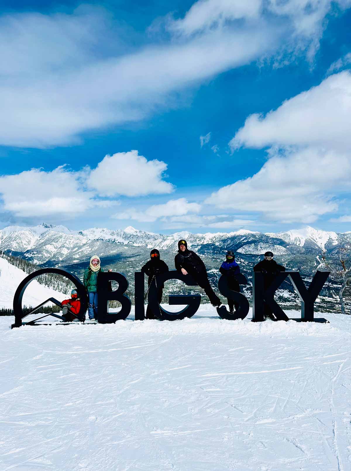 family posing by Big Sky sign.