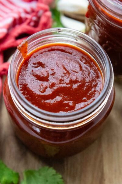 looking into the top of glass jar with enchilada sauce.