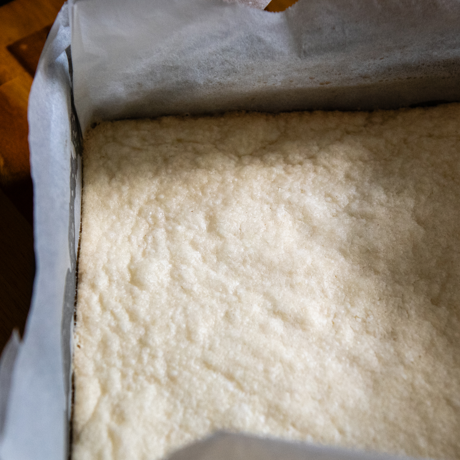 Baked dough in parchment paper in a pan.