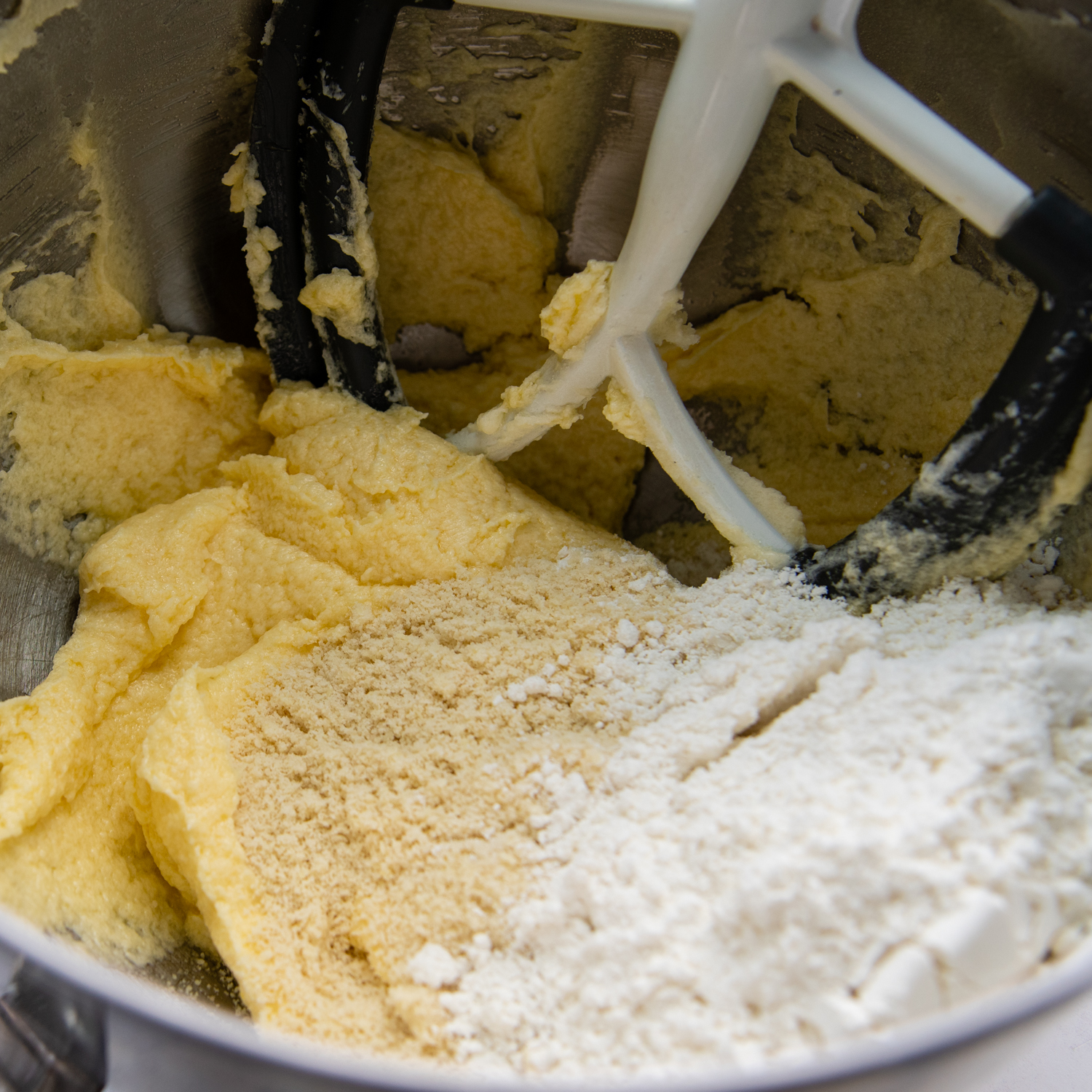 Additional ingredients being added to the mixing bowl.