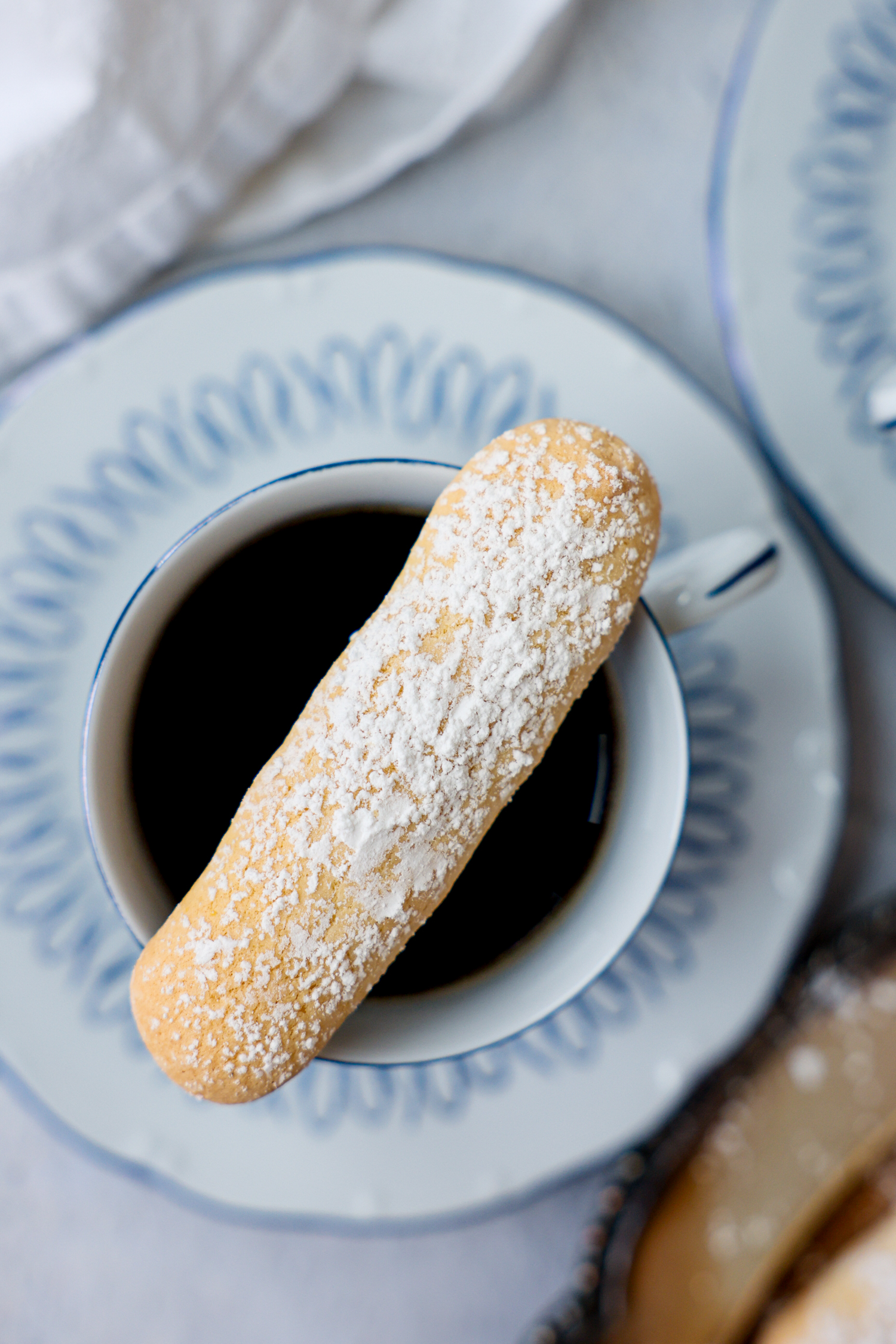 Lady finger on top of a cup of tea.