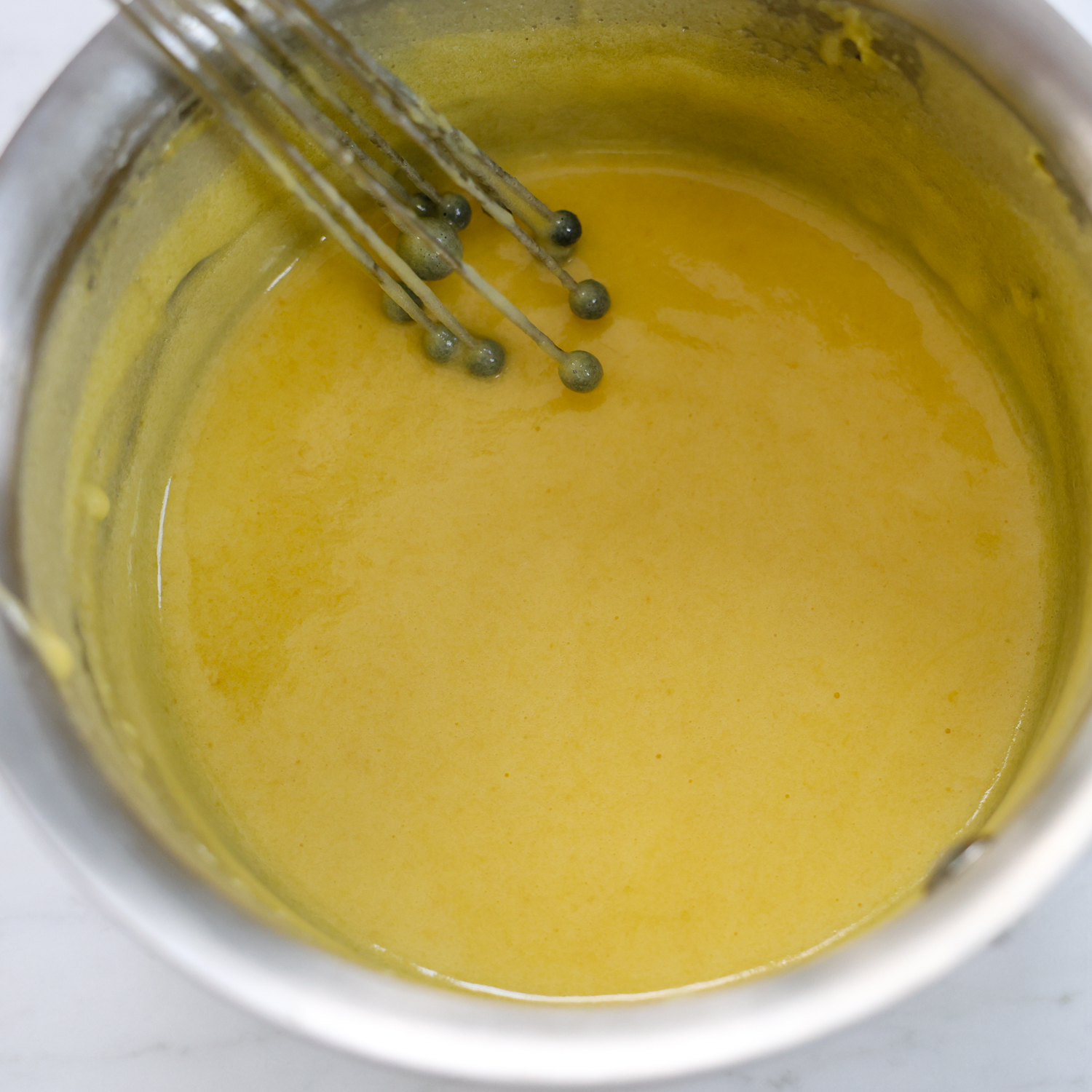 Egg and sugar mixture in a glass bowl.