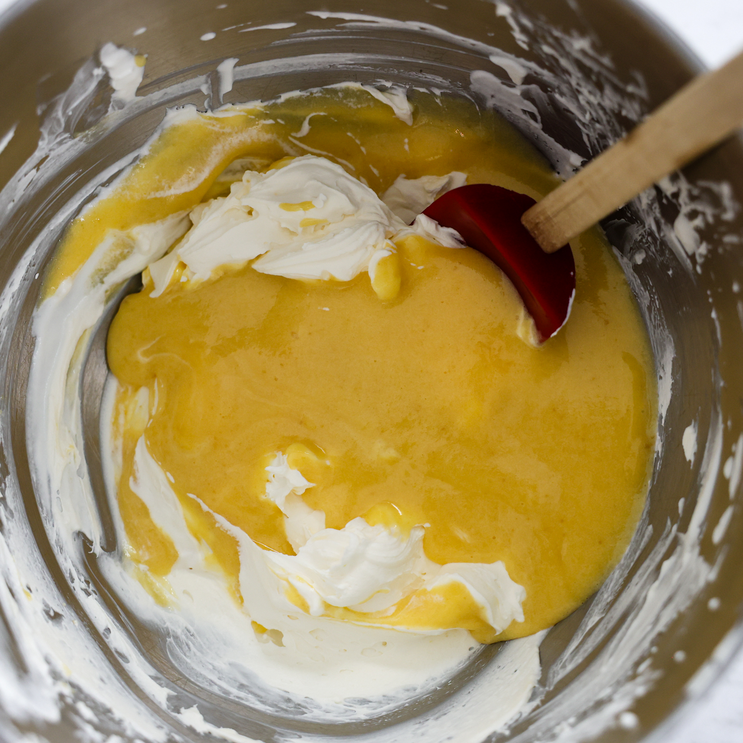 Egg mixture and mascarpone mixtures being combined.