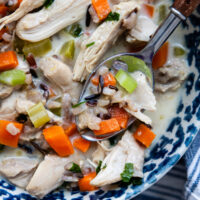 Bowl of creamy chicken and rice soup with a soup.