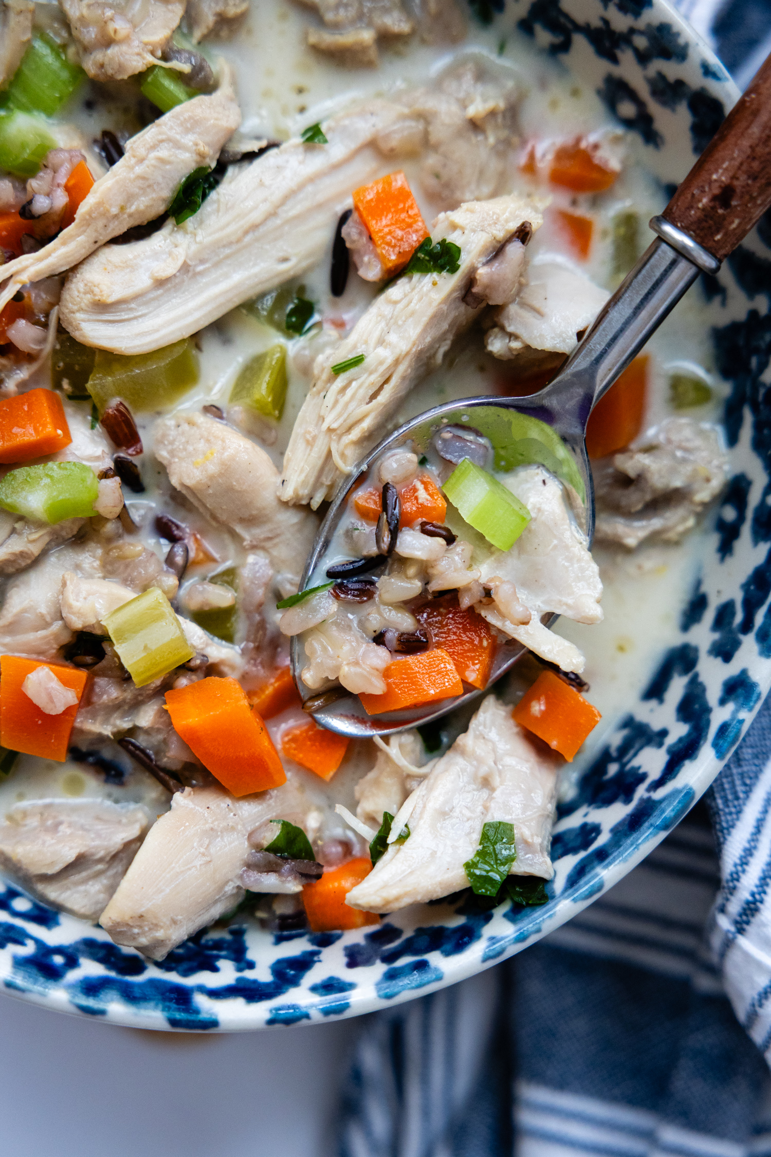 Bowl of creamy chicken and rice soup with a soup.