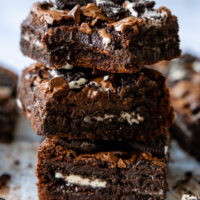 Gluten Free Oreo Brownie squares stacked on top of one another.
