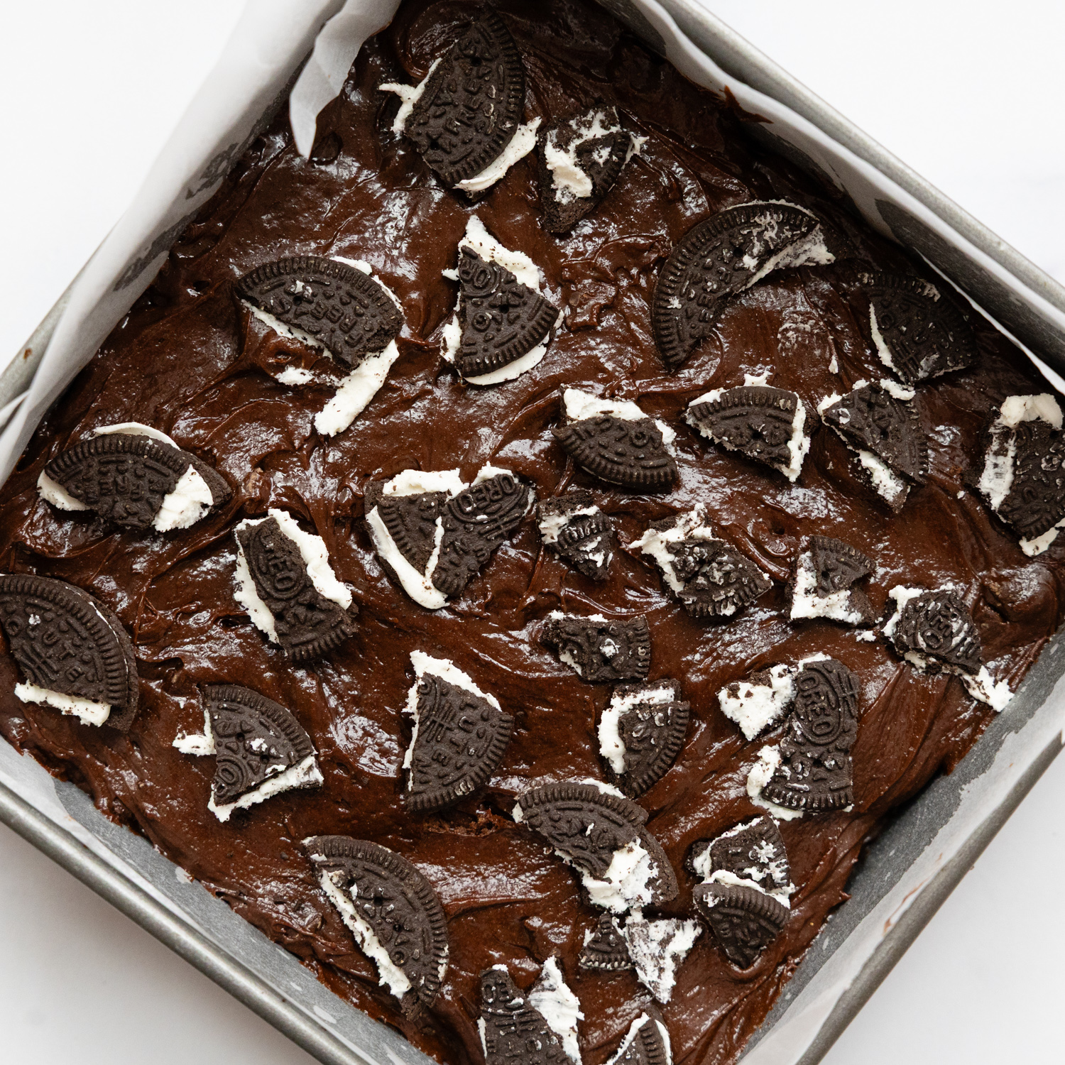 Gluten free Oreo pieces on top a brownie batter.