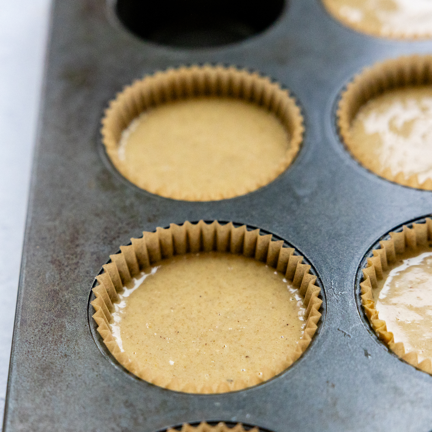 Muffin ingredients in muffin cups ready to bake.