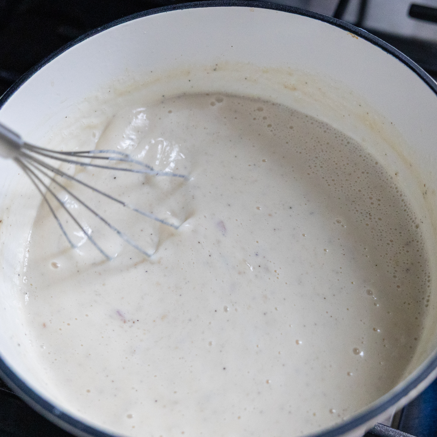 Broth being whisked into flour mixture.