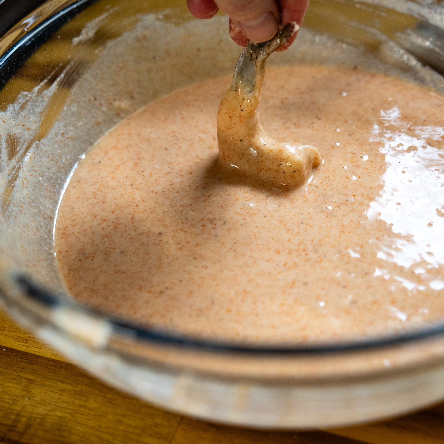 Shrimp being dipped in batter.