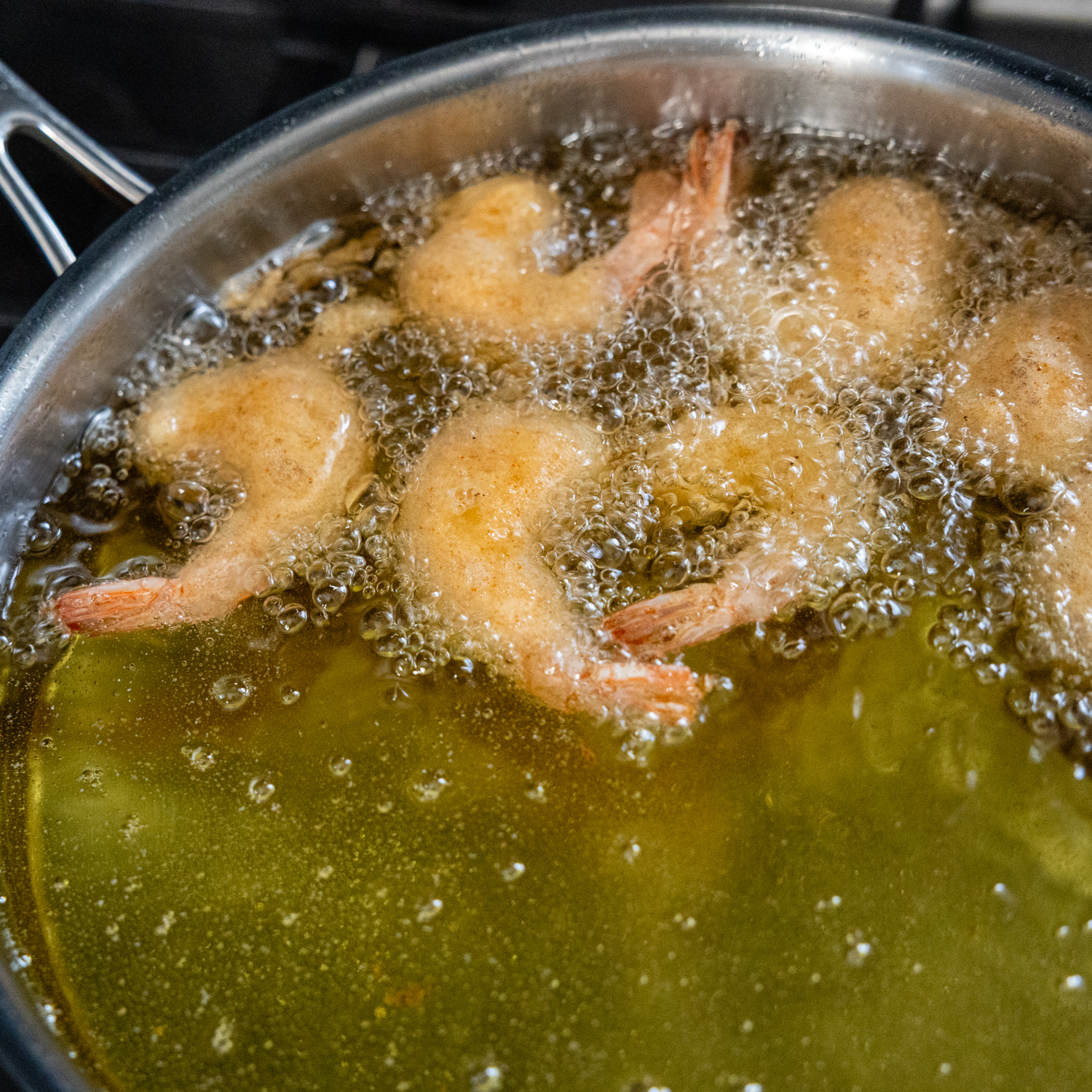 Battered shrimp being fried.