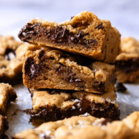 Stack of chocolate chip cookies bars show the cross section and internal melted chocolate.