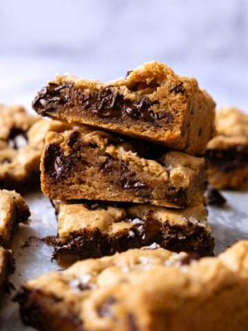 Stack of chocolate chip cookies bars show the cross section and internal melted chocolate.