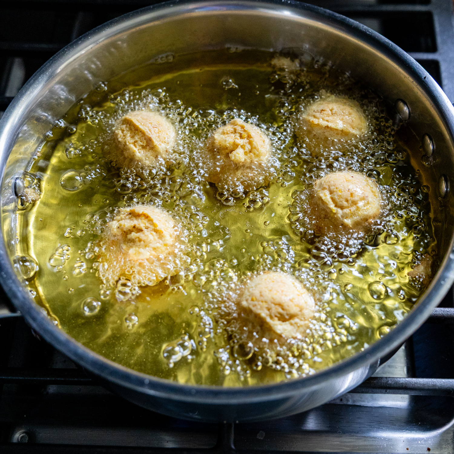 Hush puppies added to the oil for frying.