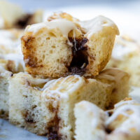 stack of two slices of cinnamon roll focaccia on a marble surface.