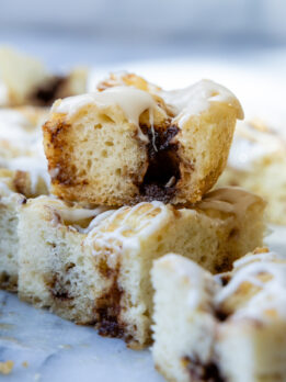 stack of two slices of cinnamon roll focaccia on a marble surface.