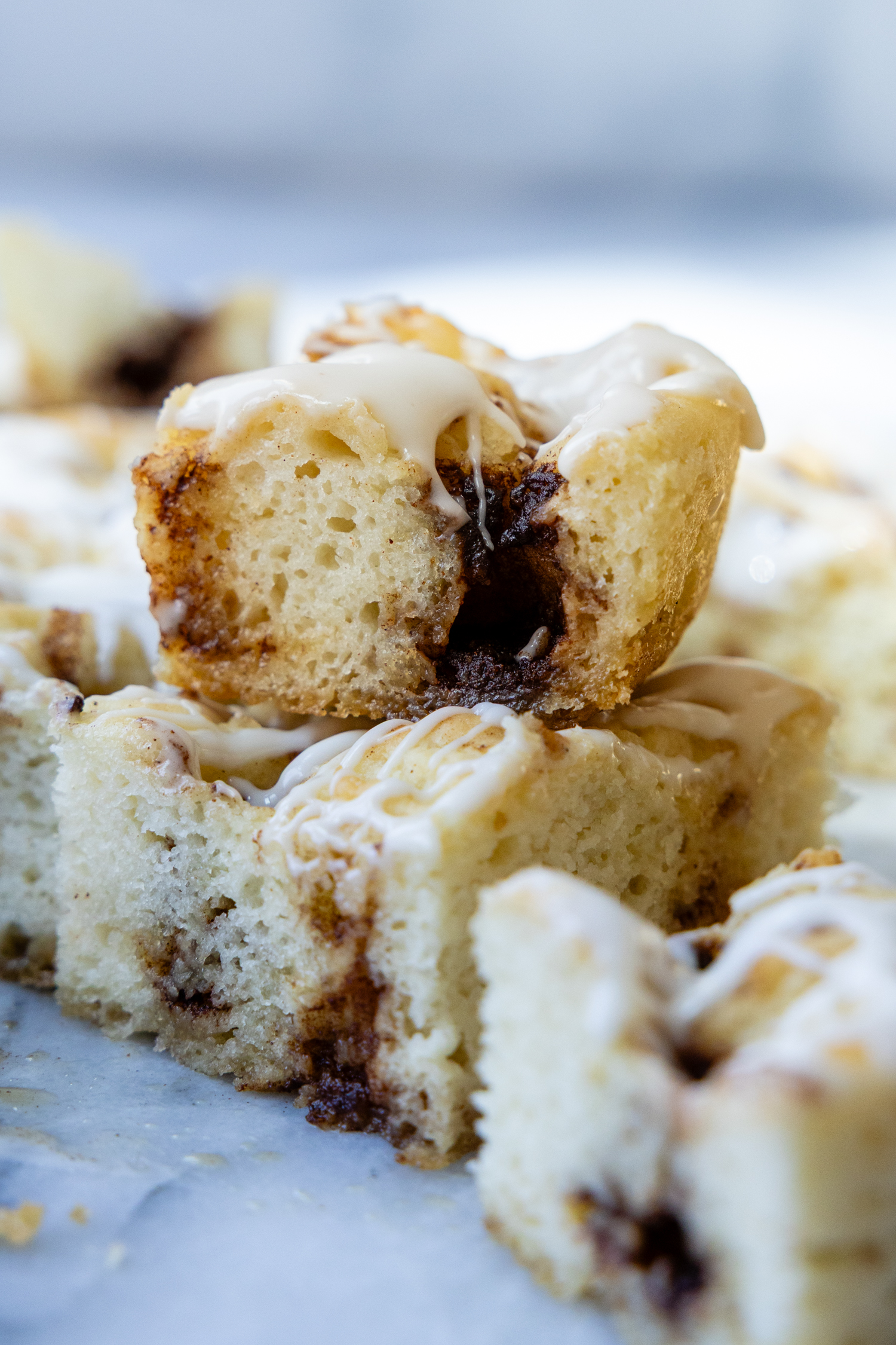 stack of two slices of cinnamon roll focaccia on a marble surface.