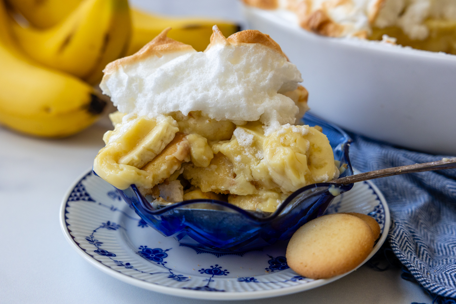 Banana pudding with wafers in a blue bowl.