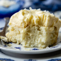 Close up of a piece of coconut cake on a plate.