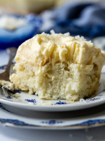 Close up of a piece of coconut cake on a plate.
