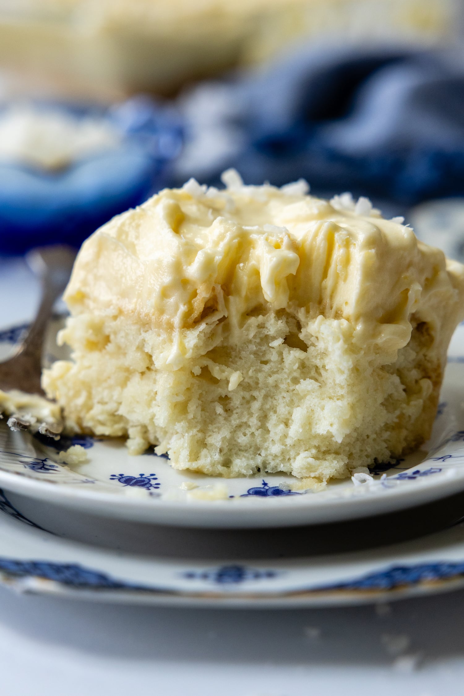 Close up of a piece of coconut cake on a plate.