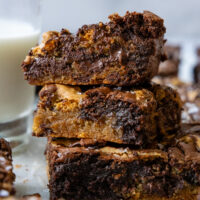 Three brookie brownies stacked on top of one another showing the inside moisture and chocolate.