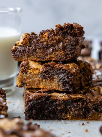 Three brookie brownies stacked on top of one another showing the inside moisture and chocolate.