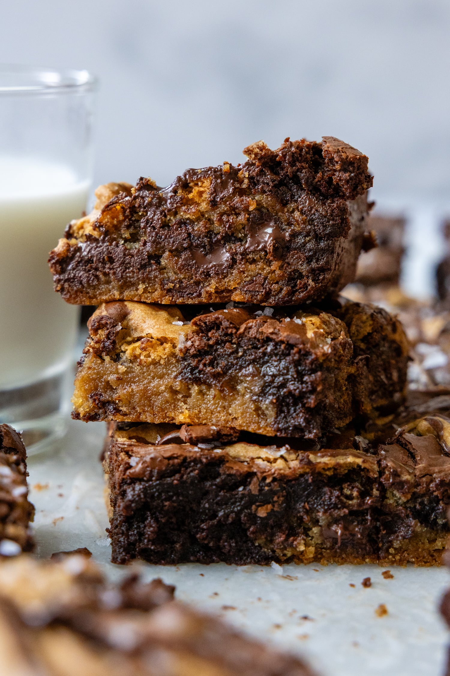 Three brookie brownies stacked on top of one another showing the inside moisture and chocolate.